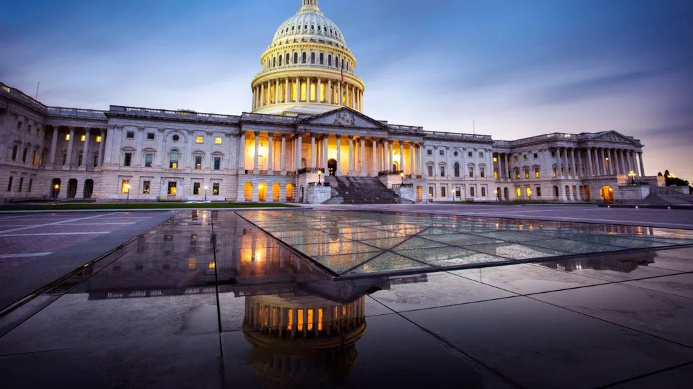 ALT Text: an Image of the Capital building with the Sun set in the background